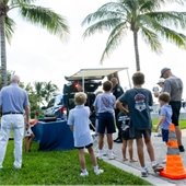 crowd gathered listening to a police officer learning about a drone